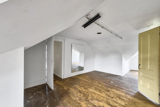 additional living space with baseboards, lofted ceiling, and wood-type flooring