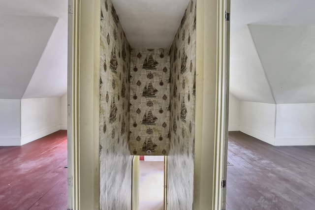 bathroom featuring baseboards, lofted ceiling, and wood finished floors