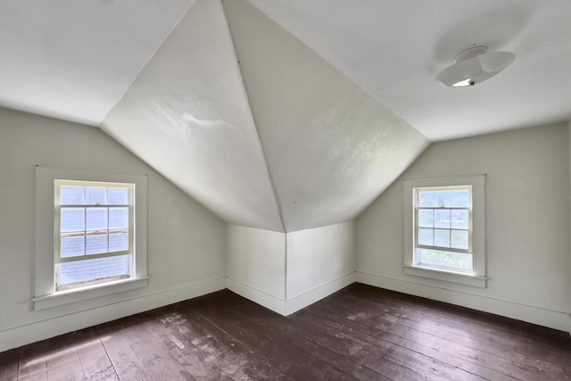 bonus room featuring dark wood-style floors, lofted ceiling, and baseboards