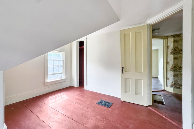 additional living space with hardwood / wood-style flooring and lofted ceiling