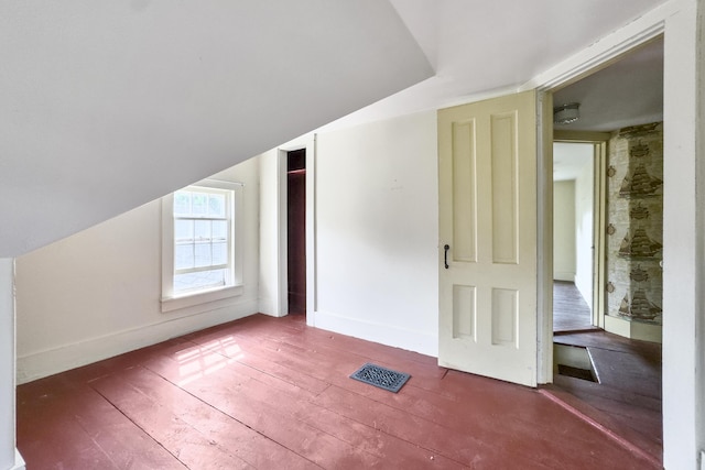 bonus room with vaulted ceiling, visible vents, baseboards, and hardwood / wood-style floors