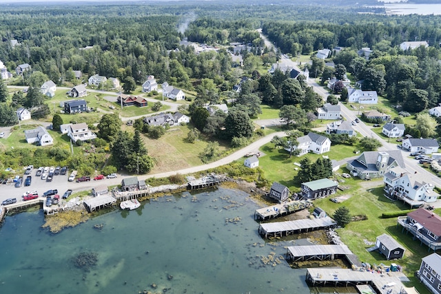 bird's eye view with a water view and a wooded view
