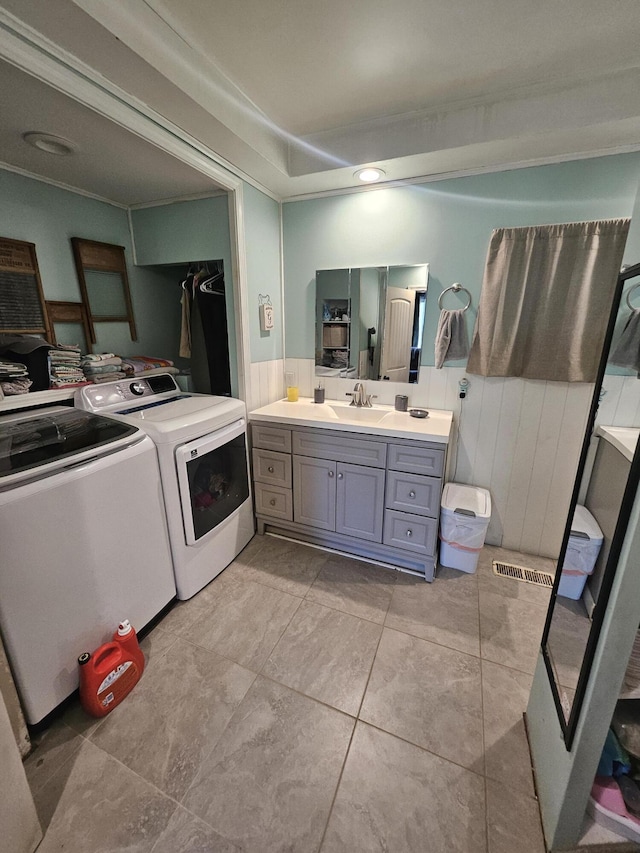 bathroom with tile patterned floors, washer and clothes dryer, and vanity