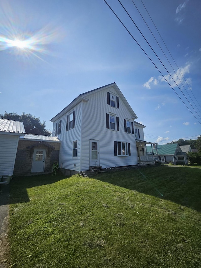 rear view of property featuring a lawn