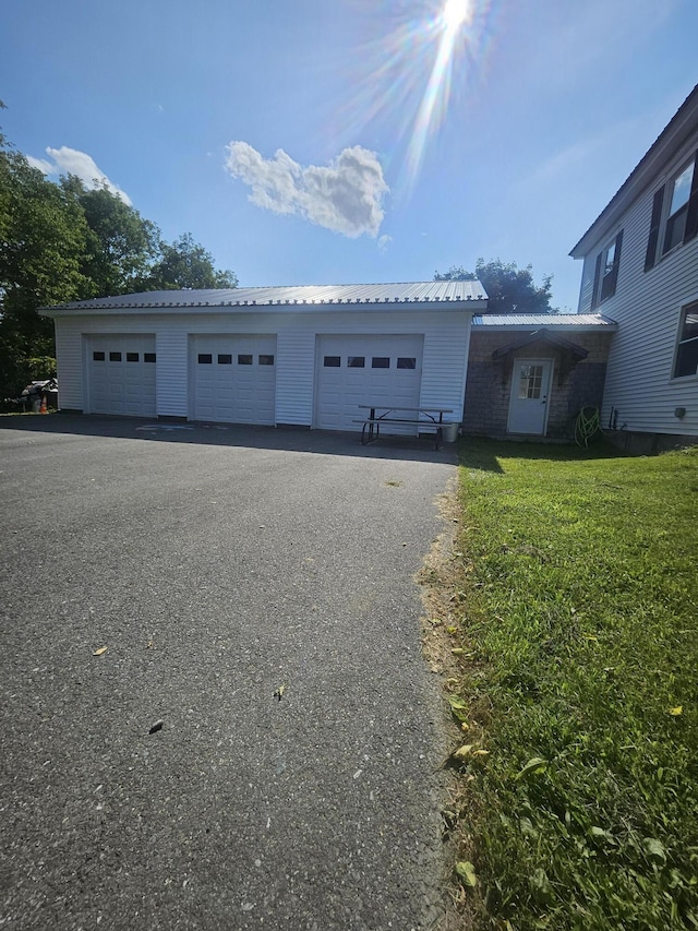 view of front facade featuring an outbuilding, a garage, and a front lawn