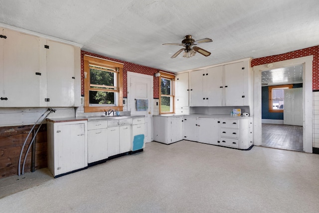 kitchen with white cabinetry, ceiling fan, sink, and a textured ceiling