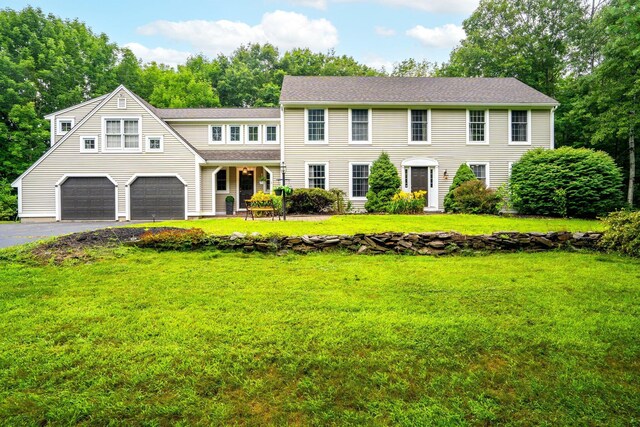 colonial home with a garage and a front lawn