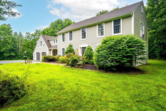 colonial-style house featuring a front lawn