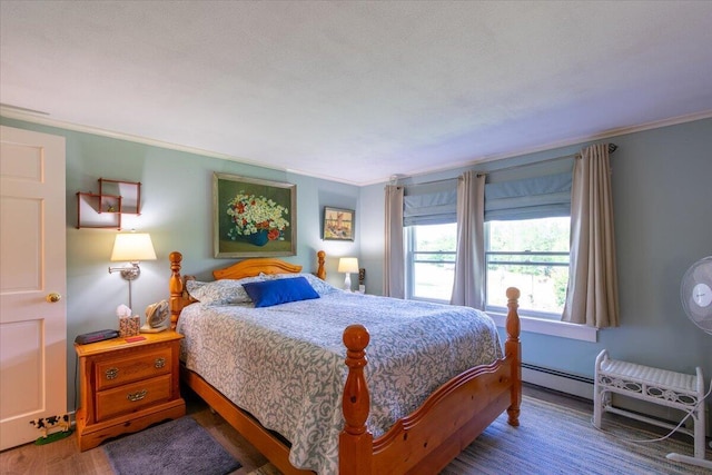 bedroom with hardwood / wood-style flooring, ornamental molding, and a baseboard radiator