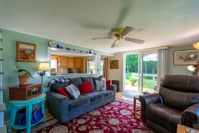 living room with crown molding, a textured ceiling, ceiling fan, and light hardwood / wood-style floors