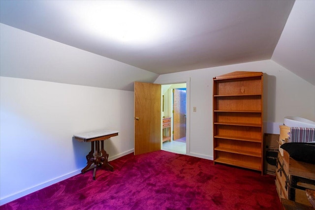 bonus room with lofted ceiling and dark carpet