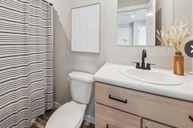 bathroom featuring curtained shower, vanity, and toilet