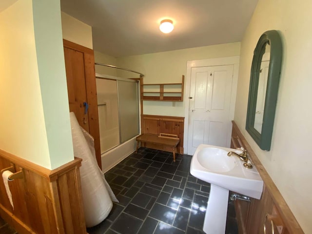 full bath featuring combined bath / shower with glass door and a sink