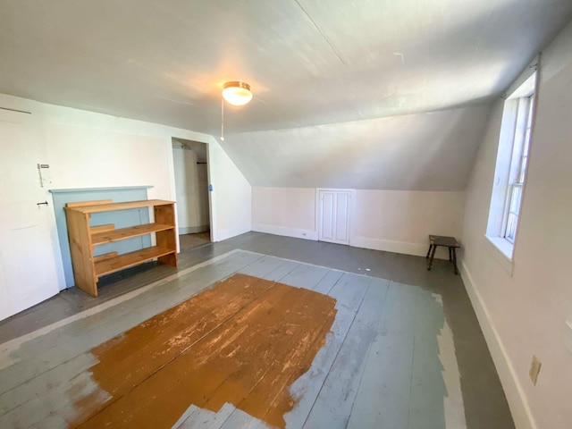 additional living space with lofted ceiling, wood-type flooring, and baseboards