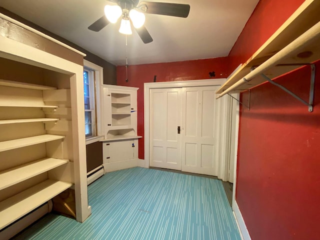 walk in closet featuring ceiling fan, a baseboard heating unit, and carpet flooring