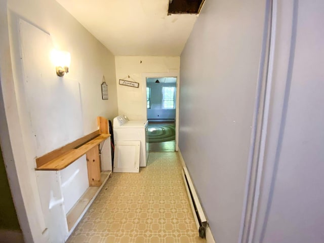 corridor with light floors, a baseboard radiator, and washing machine and dryer