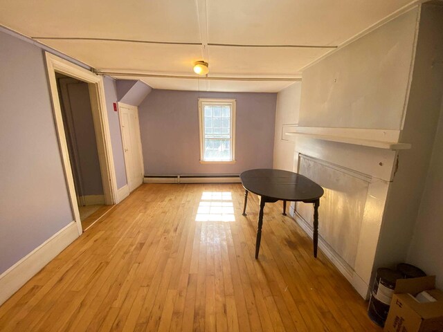 additional living space featuring light wood-style flooring, baseboards, and baseboard heating