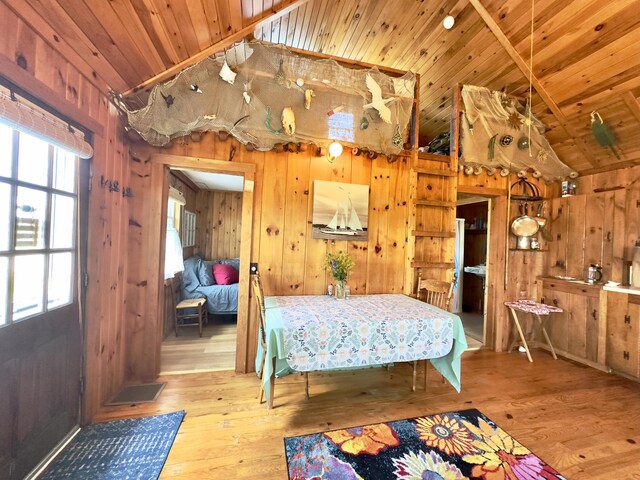 bedroom featuring wood walls, light wood-type flooring, and wooden ceiling