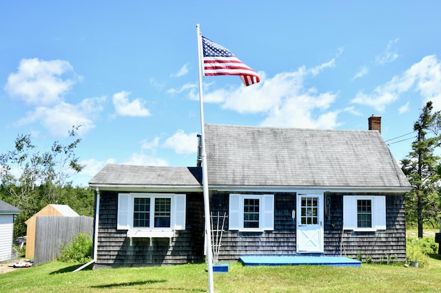 view of front of home featuring a chimney, a front yard, and fence