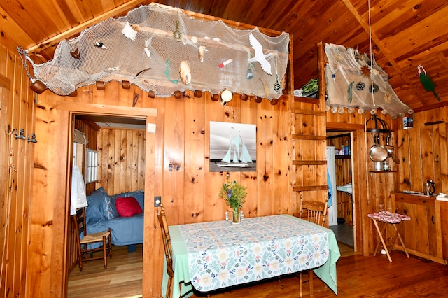 bedroom with lofted ceiling, hardwood / wood-style flooring, wooden walls, and wooden ceiling