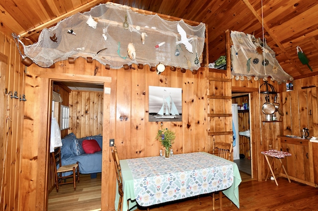 bedroom featuring lofted ceiling, wooden ceiling, wood walls, and wood finished floors