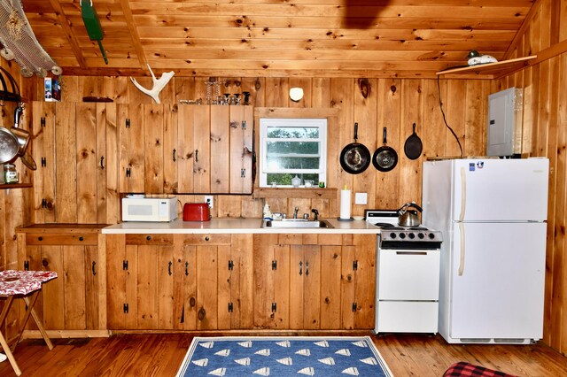 kitchen with white appliances, wood walls, wood-type flooring, and wood ceiling