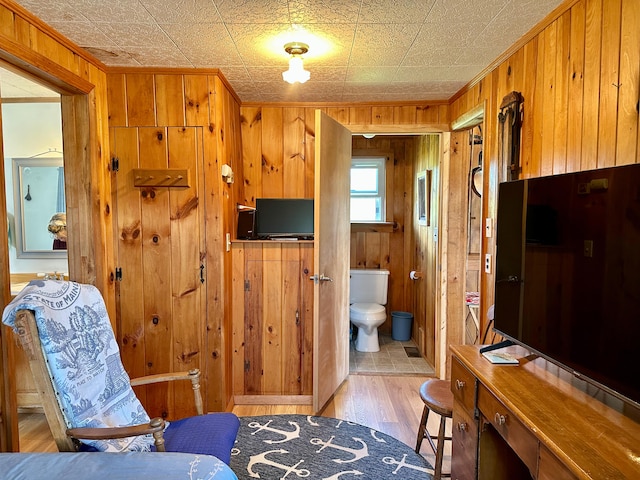 living area with light hardwood / wood-style flooring and wooden walls