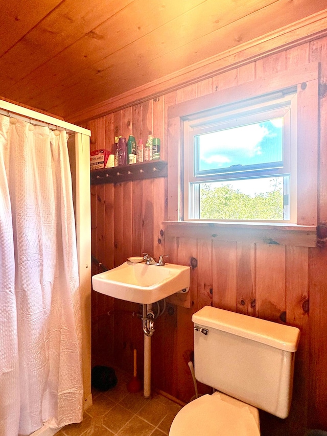 full bath with wooden ceiling, wood walls, toilet, and tile patterned floors