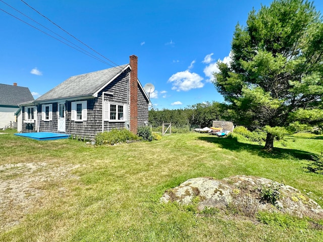 view of property exterior with a chimney and a yard