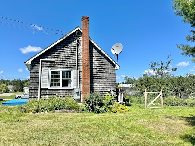 view of property exterior with a chimney and a lawn