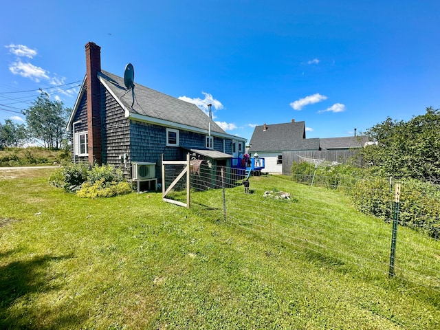 back of property with a chimney and a yard