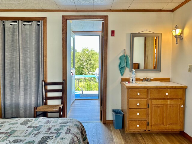 bedroom with light wood-type flooring, access to outside, and multiple windows