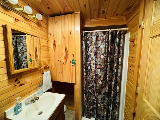 bathroom featuring vanity, wooden ceiling, and wooden walls