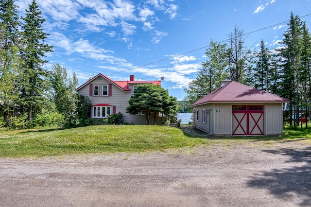 view of side of home featuring an outdoor structure and a yard