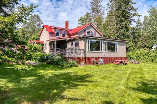 rear view of house featuring a lawn