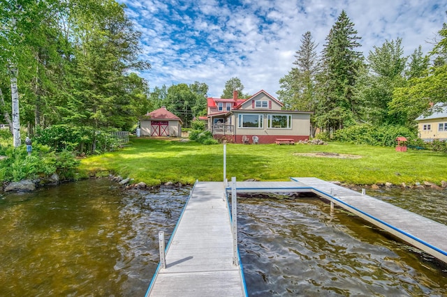 view of dock with a water view and a yard