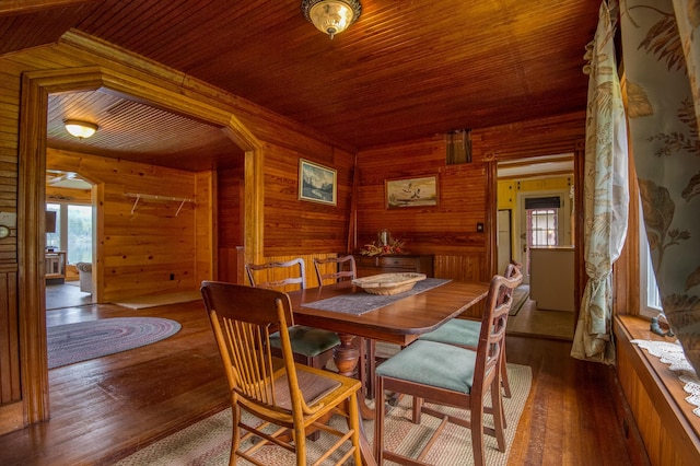 dining room with wood ceiling, wood walls, and hardwood / wood-style flooring