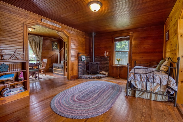 bedroom with wood walls, hardwood / wood-style floors, and wooden ceiling