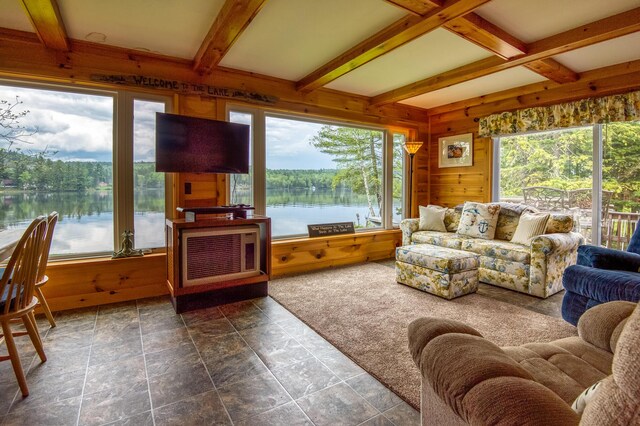 sunroom featuring a healthy amount of sunlight and beam ceiling