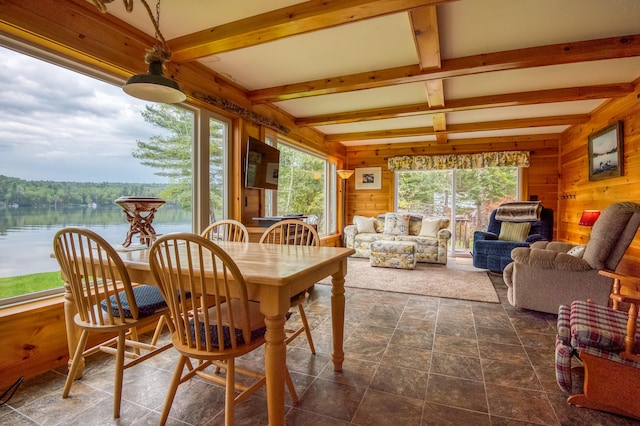 sunroom / solarium with beamed ceiling and a water view