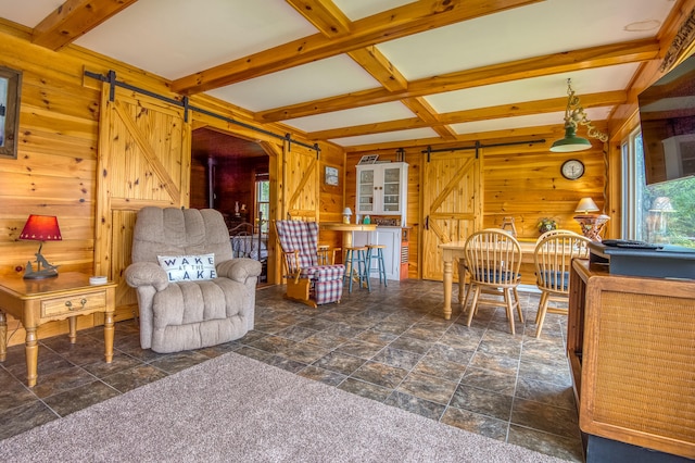 tiled living room featuring beamed ceiling, a barn door, coffered ceiling, and wooden walls