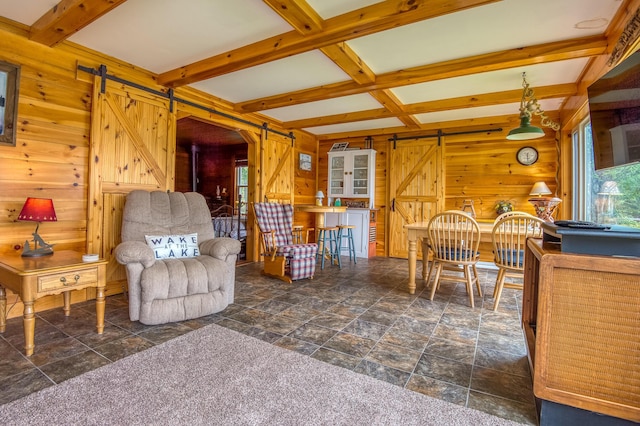 living room with coffered ceiling, wood walls, beamed ceiling, and a barn door