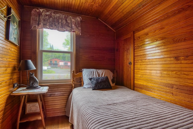 bedroom with lofted ceiling, wood walls, and wood ceiling