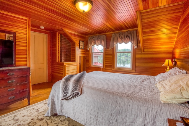 bedroom with wood walls, wooden ceiling, and light wood-type flooring