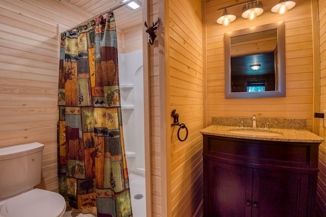 bathroom featuring vanity, wood walls, and toilet