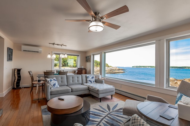 living room with a baseboard radiator, a water view, a wall mounted AC, and light hardwood / wood-style flooring