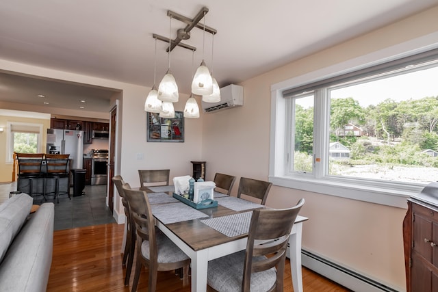 dining room featuring a wall mounted AC, a baseboard heating unit, and hardwood / wood-style flooring