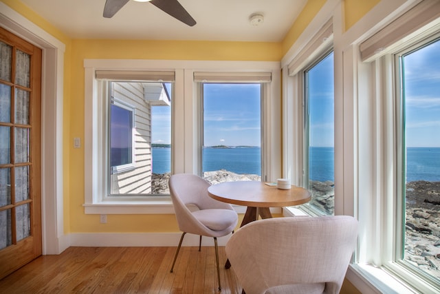 dining area featuring a water view, hardwood / wood-style flooring, and ceiling fan