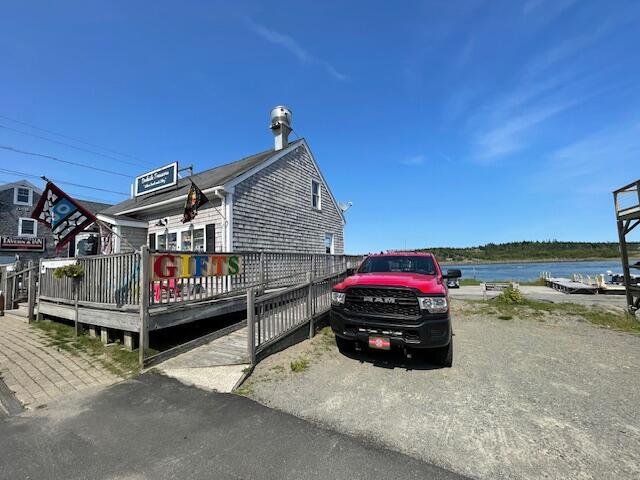 view of home's exterior with a deck with water view