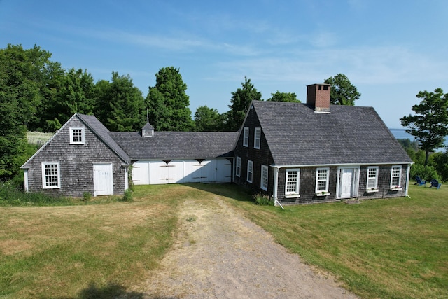 38 Kingsbury Ln, Perry, ME 04667 - cape cod-style house featuring a chimney, a front yard, dirt driveway, a shingled roof, and an outdoor structure